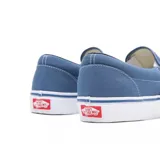 Championes Vans Classic Slip-On celestes, de capellada baja de lona sin cordones, con elástico lateral y suela de goma blanca.