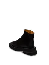 Bota de cuero negra con caña baja, punta cuadrada y suela track.