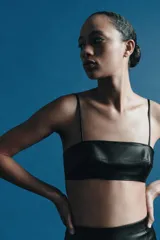 Top tipo bandeau negro de Zara Woman Collection, confeccionado en piel 100%, con escote recto y tirantes finos. Cierre en la espalda con ganchos metálicos.
