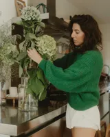 Sweater tejido verde esmeralda de alpaca y lana, con cuello redondo y mangas abullonadas.