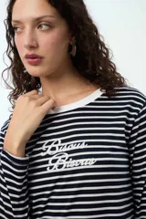 Camisón de manga larga con diseño a rayas horizontales en azul marino y blanco. Presenta escote redondo con cuello en tela rib y estampa frontal con texto bordado.