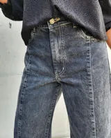 Pantalón de jean estilo wide leg con costuras verticales frontales, tiro alto y bolsillos laterales.