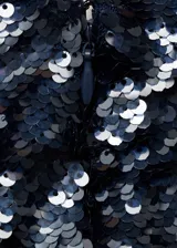 Minifalda azul marino con lentejuelas, de tiro medio, corte recto y cierre lateral invisible.