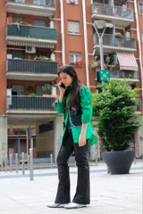 Pantalón de cuero negro, forrado, con cortes verticales y horizontales. Pretina con apliques de tachas plateadas y tajo delantero.