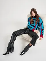 Pantalón de cuero color beige, de corte recto, con cintura alta y lazo para ajustar.