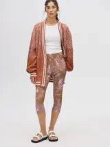 Calza deportiva de largo 3/4, confeccionada en lycra con un diseño estampado abstracto en tonos marrones y violetas.