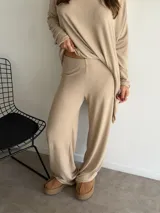 Pantalón de lanilla color negro, de corte recto y tiro alto, con diseño holgado y fluido.