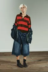 Jersey de punto a rayas horizontales en color marrón y rojo, con cuello polo y cierre frontal parcial, de manga larga y diseño holgado.