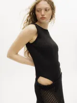 Body de lurex color negro, con diseño acanalado, cuello redondo a la base, corte cavado y espalda abierta con tiras cruzadas.