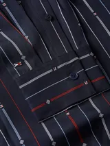 Camisa de manga larga azul marino con rayas verticales rojas y blancas, con lazo extraíble en el cuello.