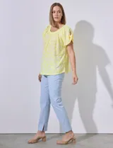 Blusa amarilla con textura labrada, escote redondo elastizado y mangas cortas con aberturas y lazos.
