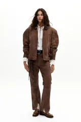 Pantalón de cuero de oveja color marrón antiguo, de corte recto, tiro medio, con elástico interno en la cintura y tajos en el ruedo.