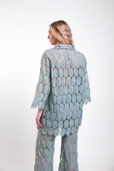 Camisa de moldería clásica confeccionada en tela de encaje de círculos de algodón, con mangas largas y cierre frontal de botones.