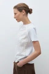 Remera de manga corta con frente confeccionado en tela broderie blanca con diseño calado y espalda de algodón liso.
