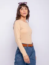 Remera blanca de manga larga con cuello redondo y frunces verticales en el centro.