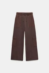Pantalón cargo de tiro medio con efecto lavado, confeccionado en algodón. Presenta cintura elástica ajustable con cordones, bolsillos laterales y bolsillos de plastrón con solapa en las piernas. Diseño de pierna recta con combinación de tejidos a tono.