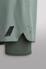 Shorts de entrenamiento azul marino con calza interior negra. Cintura elástica ajustable con cordón, bolsillos laterales con cierre y aberturas laterales en el bajo.