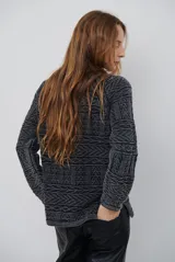 Buzo de tejido de punto en color azul con diseño geométrico texturizado, cuello redondo y mangas largas.