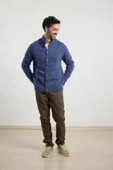 Cardigan de tejido de punto color azul piedra melange, con cuello mao y cierre frontal de botones.