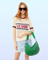 Bandolera verde de cuero tejido con correa de hombro ajustable y cierre de cremallera.