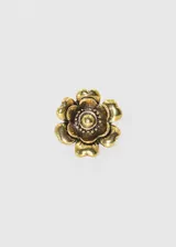 Anillo dorado con forma de flor de seis pétalos con centro circular texturizado. Diseño vintage.