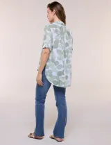Camisa de lino sintético con estampado floral en tonos azules y beige sobre fondo blanco, de corte holgado, mangas tres cuartos y cuello camisero.