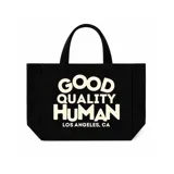 Bolso tipo tote bag color negro con asas de mano y estampado frontal en tono claro con la leyenda "Good Quality Human Los Angeles, CA".