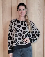Buzo de punto con estampado animal print de leopardo, cuello redondo, mangas largas y puños y ruedo en tejido liso negro.