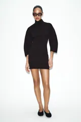 Vestido corto de tejido de punto elástico con cuello alto, manga larga y cierre posterior con cremallera.