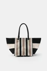Bolso tipo shopper de algodón con diseño de rayas en tonos negro, blanco y beige. Cuenta con asas de mano de piel negra, forro interior con bolsillo y cierre magnético.