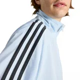 Campera deportiva Adidas Firebird color celeste con cierre frontal, cuello alto y bolsillos laterales con cierre. Presenta las icónicas tres tiras negras en los hombros y mangas, y el logo del trifolio bordado en el pecho.