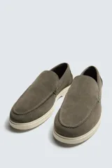 Mocasín casual de hombre, color azul marino, con parte superior de serraje (gamuza) y suela de goma a contraste color beige. Presenta un detalle de bordón cosido en la pala.