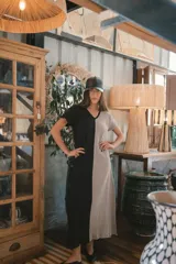 Vestido largo de punto acanalado en color negro, con escote en V, mangas cortas y aberturas laterales en el ruedo.