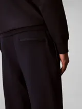 Pantalón de jogging Calvin Klein de felpa color azul marino, con cintura elástica, cordón ajustable, bolsillos laterales y puños elásticos en los tobillos. Cuenta con el monograma CK bordado discretamente en la pierna.