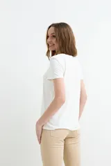 Remera negra de manga corta, con escote en V adornado con detalle de broderie.