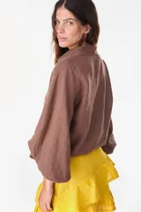 Camisa de lino italiano con estampado a rayas verticales irregulares, de corte holgado, cuello clásico, mangas abullonadas y cierre frontal con botones.