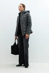 Campera gris oscuro de eco-cuero capitoneada con capucha y cierre frontal.