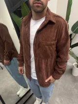 Sobrecamisa de pana color marrón chocolate, con cuello clásico, cierre frontal de botones y un bolsillo en el pecho.