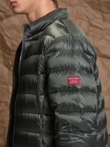Campera puffer de plumas en color azul marino, con cierre frontal, cuello alto y diseño acolchado horizontal.