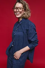 Camisa de manga larga con diseño de rayas verticales y horizontales en color marrón. Presenta un corte oversize con hombros caídos, cuello clásico y cierre frontal con botones.