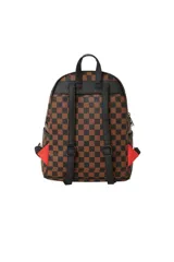 Mochila Sprayground de ecopiel con diseño a cuadros en tonos marrón y negro, y estampado de boca de tiburón rosa con efecto dripping.