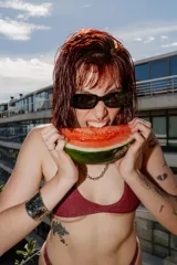 Top de bikini color bordó con acabado brillante, de corte triangular y tirantes finos que se atan en la espalda y el cuello.