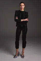 Pantalón negro de lycra con semi brillo y detalle de recogido en el costado de la basta.