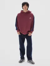 Hoodie de felpa con frisa suave, color negro, con calce oversized y franjas laterales en contraste.