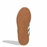 Championes Adidas modelo Grand Court Alpha, color verde oscuro con las icónicas tres tiras laterales en tono crema. Presentan un diseño de inspiración retro, con capellada de cuero sintético, entresuela blanca con tecnología Cloudfoam para mayor amortiguación y suela de goma en tono caramelo.