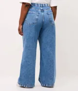 Pantalón de jean corte wide leg, color azul medio, con cintura de tiro alto, cierre de botón y bolsillos laterales. Confeccionado en tejido de algodón estructurado.
