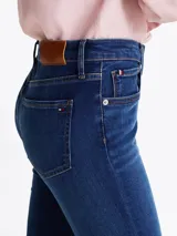 Pantalón jean skinny de tiro medio, color azul oscuro, con efecto desteñido en muslos y rodillas.
