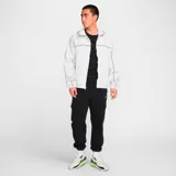 Pantalón de jogging negro con cintura elástica ajustable con cordón, bolsillos laterales y bolsillo cargo con solapa en la pierna. Logo de Nike bordado en blanco en la cadera izquierda.