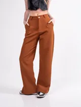 Pantalón sastrero de tiro alto color marrón, con pinzas delanteras, bolsillos laterales y traseros, y tajito lateral. Corte palazzo.