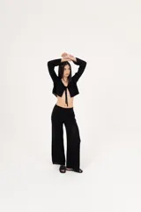 Pantalón negro de tejido de punto calado, con corte palazzo y cintura alta.